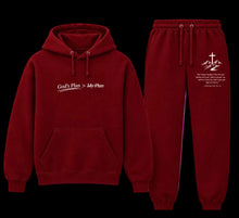 Load image into Gallery viewer, A matching two-piece hoodie and jogger sweatpants set in deep red. The hoodie features the text 'God's Plan > My Plan' printed in white on the chest, while the joggers have a white graphic of a cross over mountains and a Bible verse on the left leg.